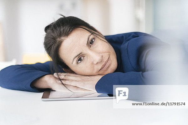 Portrait of businesswoman leaning on desk