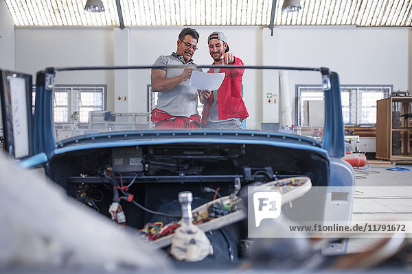 Mechaniker restaurieren Oldtimer in der Werkstatt