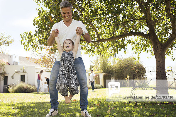 Vater spielt mit Tochter im Gras