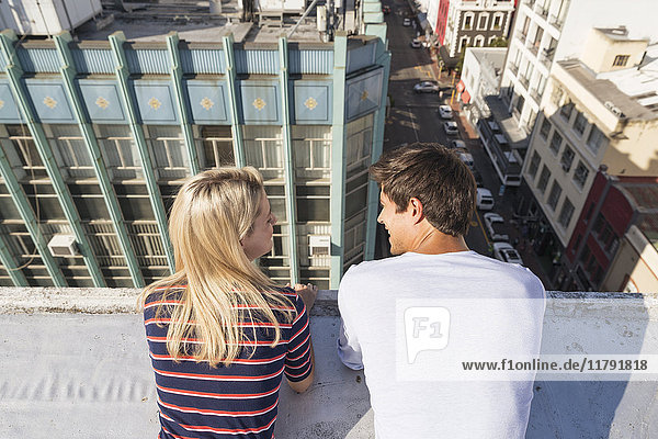 Young couple talking on a rooftop terrace