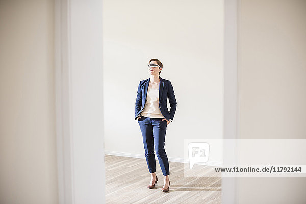 Frau in leerer Wohnung mit Smartbrille
