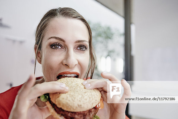 Frau beim Essen eines veganen Hamburgers
