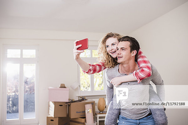 Happy young couple in new home taking a selfie