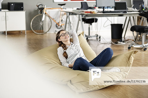 Young woman relaxing in bean bag in office