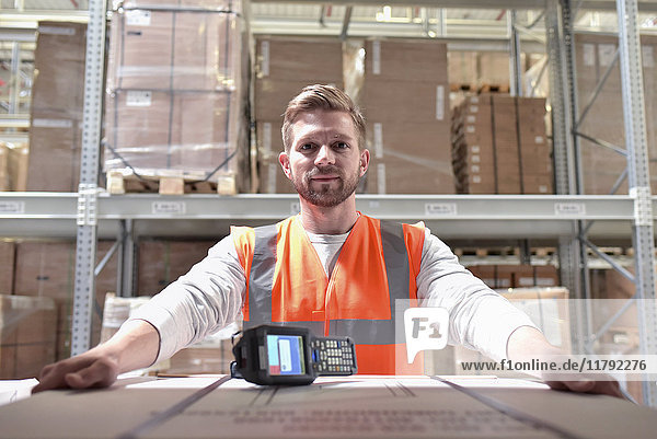 Portrait of confident man in factory hall with barcode scanner