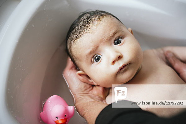 Frau badet Baby in der Wanne