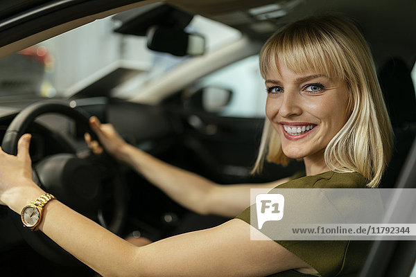 Blonde Frau wählt neues Auto im Autohaus