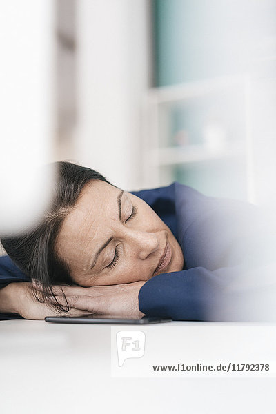 Overworked woman sleeping on laptop in office