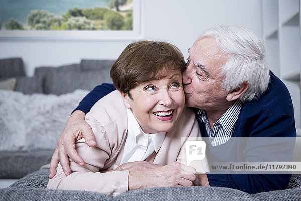 Seniorenpaar auf der Couch liegend  umarmend und küssend