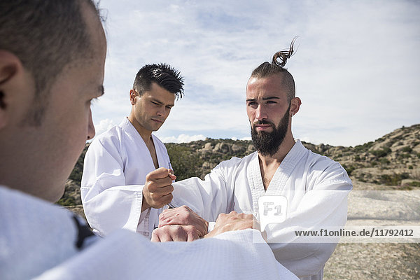 Men doing grip exercises during a martial arts training