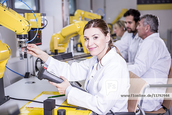 Porträt eines lächelnden Ingenieurs bei der Untersuchung von Industrierobotern