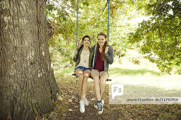 Two best friends sitting together on a swing