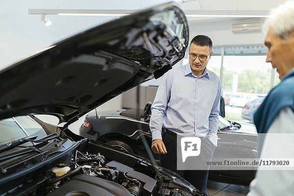 Salesman advising customer in car dealership