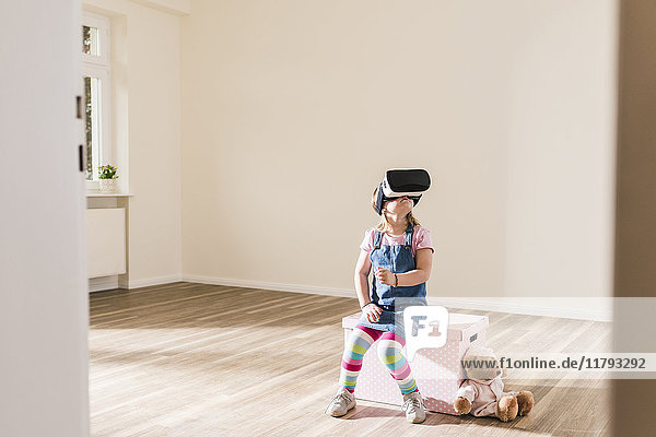 Mädchen in leerer Wohnung mit VR-Brille