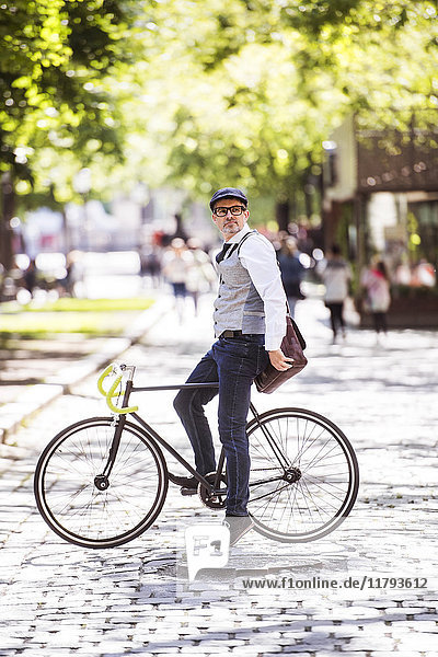 Erwachsener Geschäftsmann auf dem Fahrrad in der Stadt