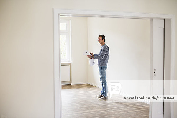 Young man in new home holding plan