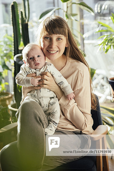 Mother holding her newborn baby boy at home