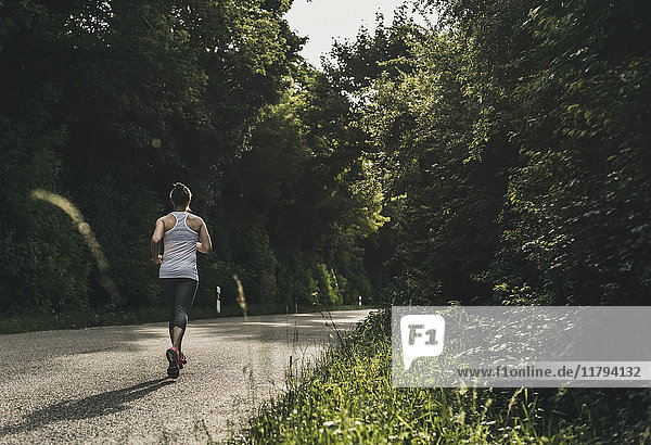 Woman running on country road