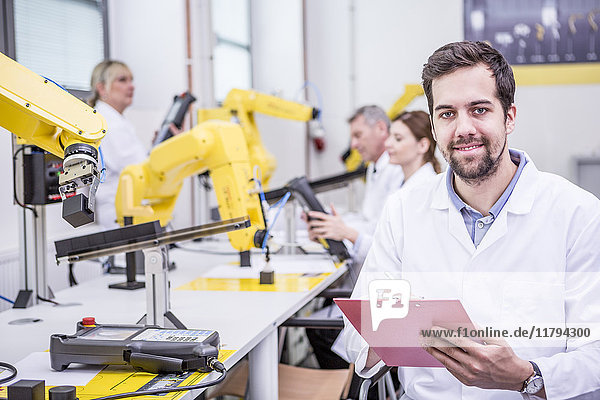 Porträt eines lächelnden Ingenieurs in der Fabrik mit Zwischenablage