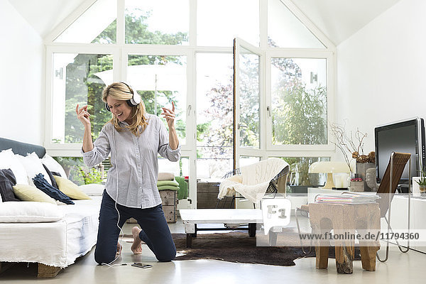 Excited woman at home listening to music