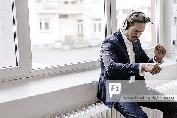Leidenschaftlicher Geschäftsmann beim Hören von Musik über Kopfhörer