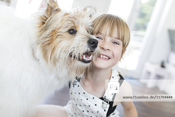 Glückliches Mädchen mit Hund zu Hause