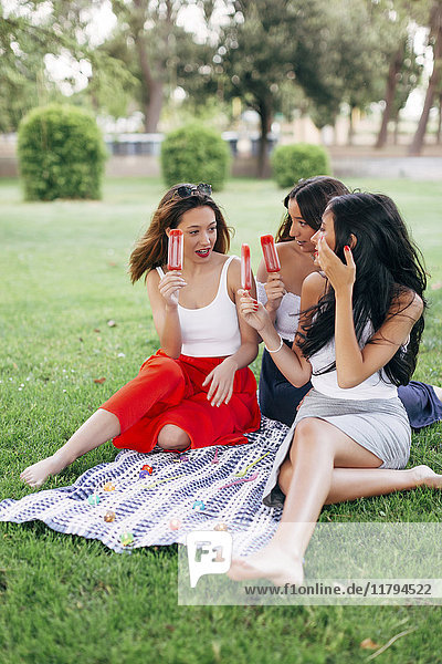 Friends in a park enjoying popsicles