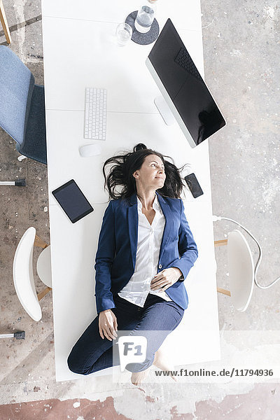 Businesswoman lying on desk in the office