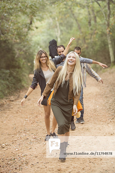 Vier glückliche Freunde  die sich auf dem Weg durch den Wald amüsieren.