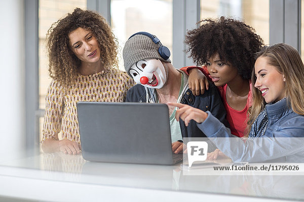 Mann im Büro trägt Maske teilen Laptop mit Kollegen