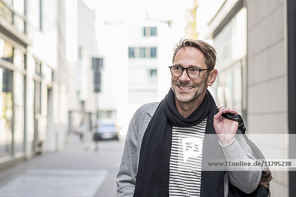 Porträt eines lächelnden reifen Mannes mit Stoppel und Brille