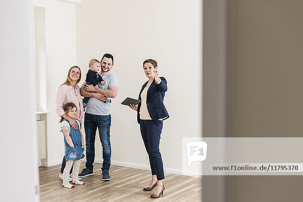 Immobilienmakler und Familie in neuer Wohnung