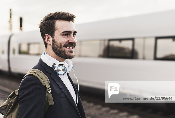 Smiling young man on platform as train coming in