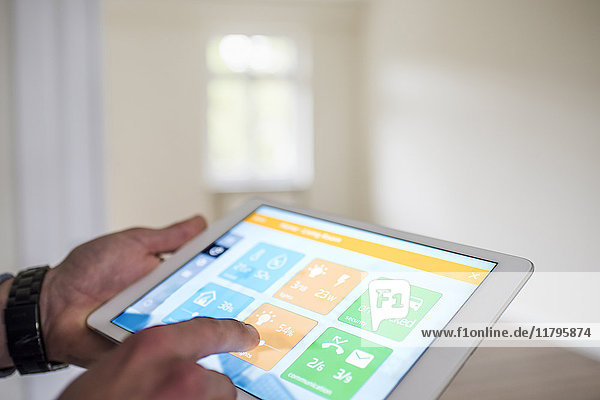 Man in new home using tablet with smart home apps