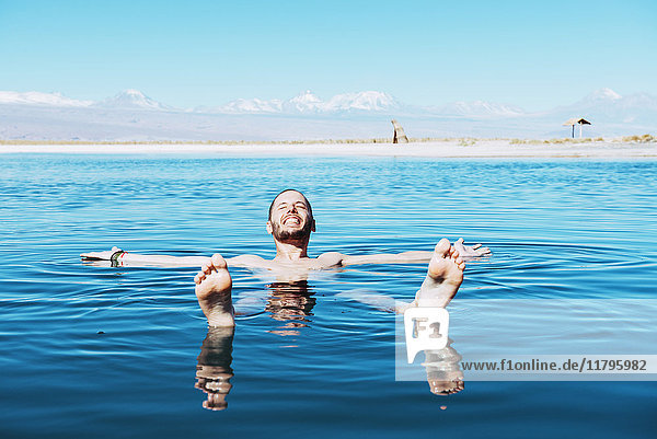 Chile  Atacama-Wüste  glücklicher Mann  der in Laguna Cejar schwimmt
