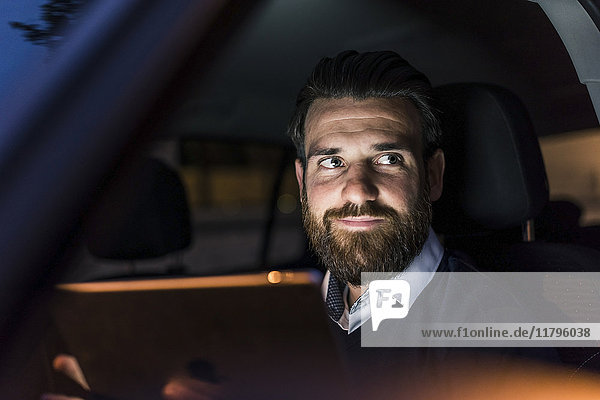 Portrait of confident businessman in car at night