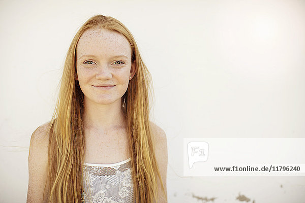 Porträt eines lächelnden Mädchens mit langen roten Haaren