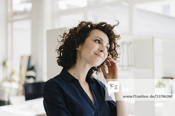 Businesswoman in office thinking and smiling