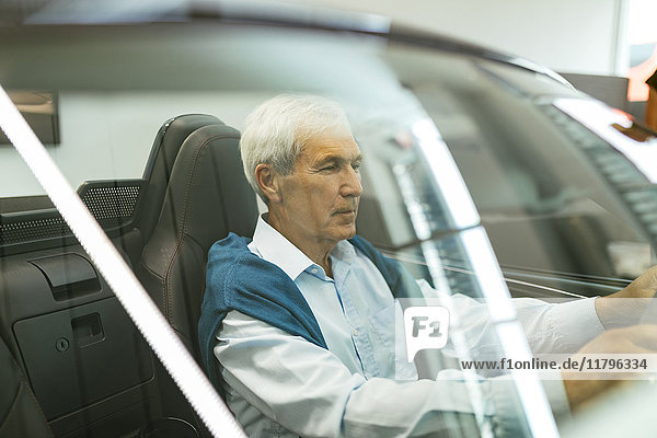 Senior Mann testet Cabriolet im Autohaus