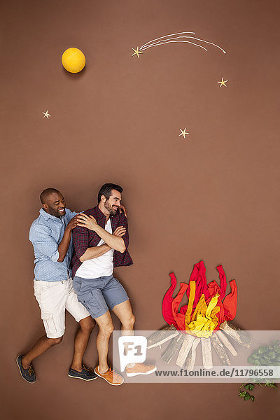 Schwules Paar beim Umarmen am Lagerfeuer