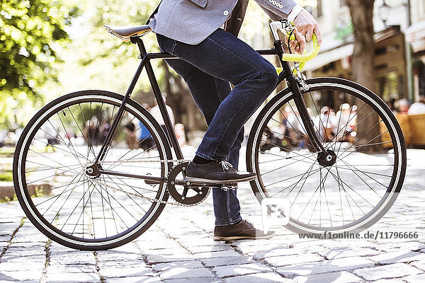 Unbekannter Geschäftsmann mit Fahrrad in der Stadt
