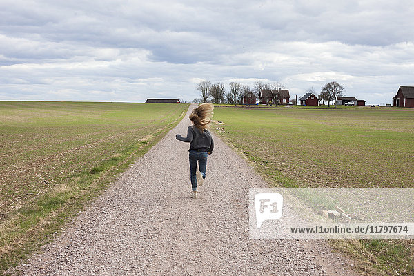 Mädchen läuft auf Feldweg