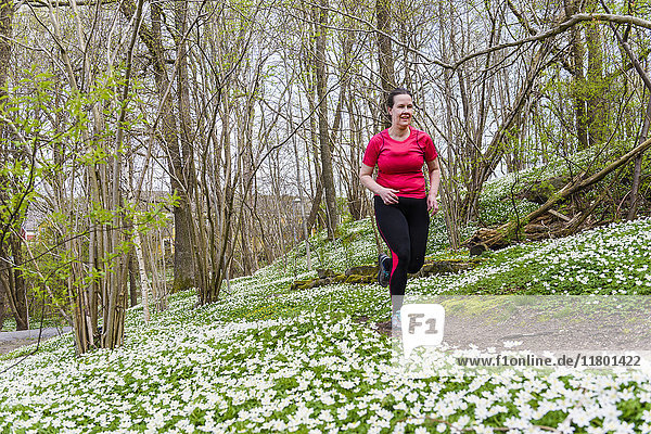 Frau läuft im Frühlingswald