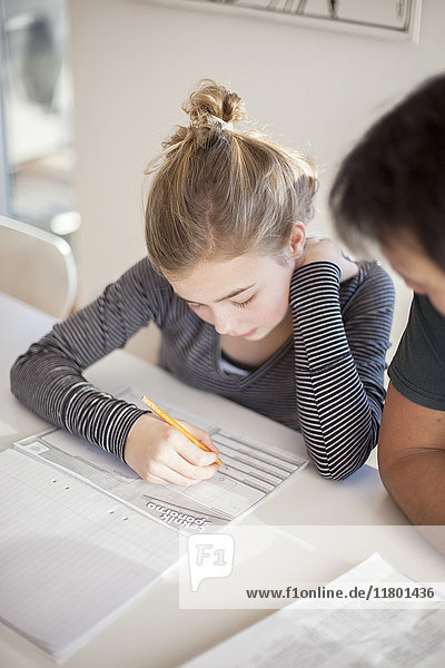 Vater hilft Tochter bei den Hausaufgaben