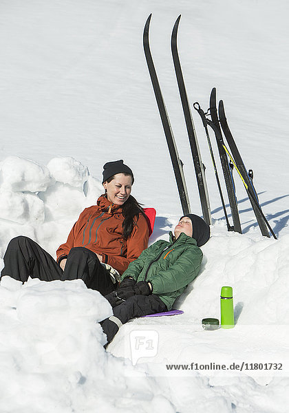 Mutter mit Sohn ruht sich im Schnee aus