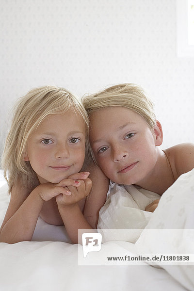 Portrait of sibling in bed