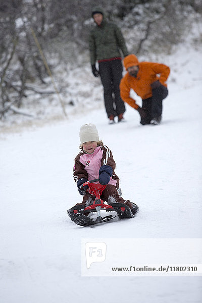 Girl riding on sledge on snow