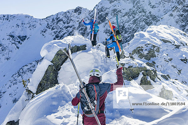 Rückansicht von Skifahrern  die auf einen Schneeberg steigen