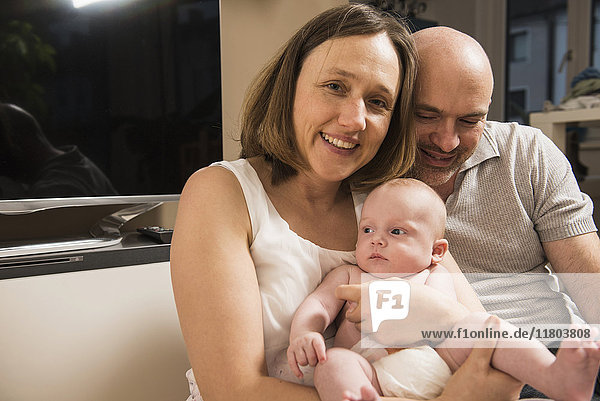 Porträt einer glücklichen Familie  die ihr Baby zu Hause hält