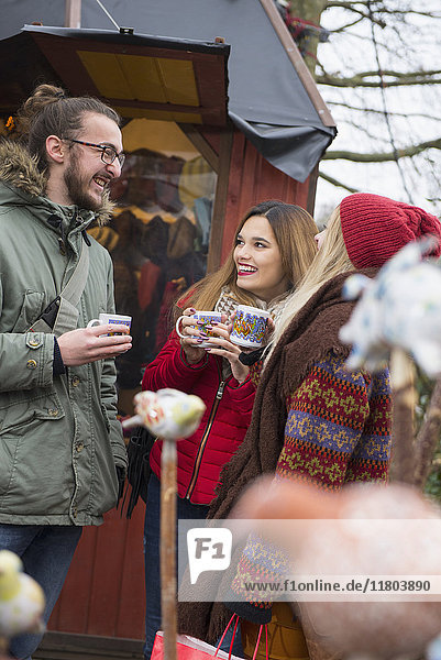 Friends drinking mulled wine at Christmas market